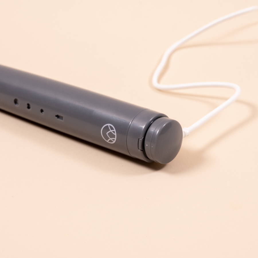 The Waken Sonic Toothbrush handle with its USB charging cord attached