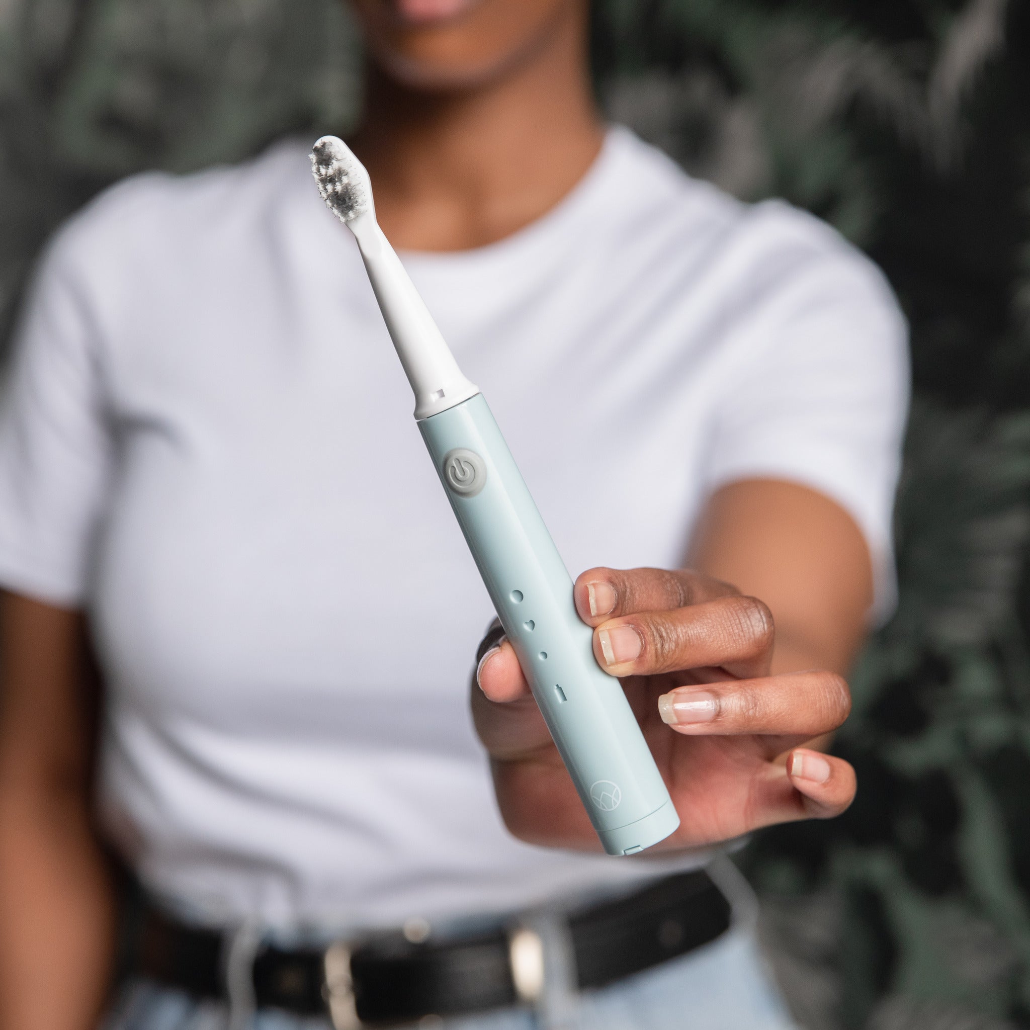 Woman holding the Waken Sonic Toothbrush in mint blue