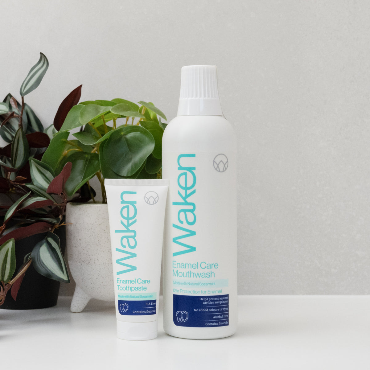 Waken Enamel Care Mouthwash and Toothpaste on a bathroom shelf